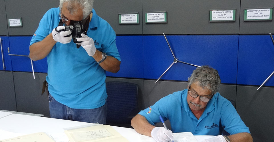 Dos colaboradores documentando obras en el Acopio del Museo de Arte Costarricense